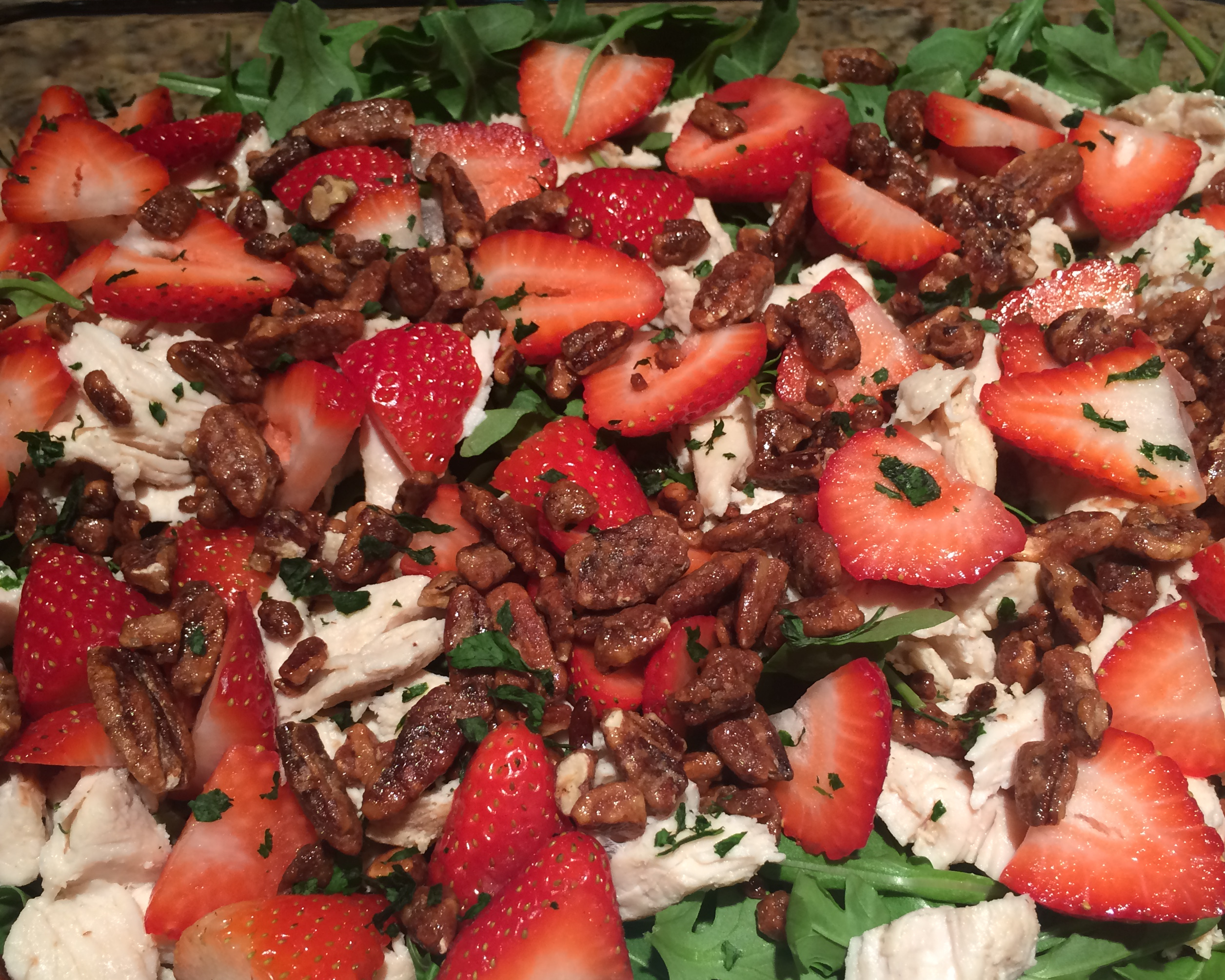 Arugula salad with grilled chicken, strawberries, candied pecans and goat cheese